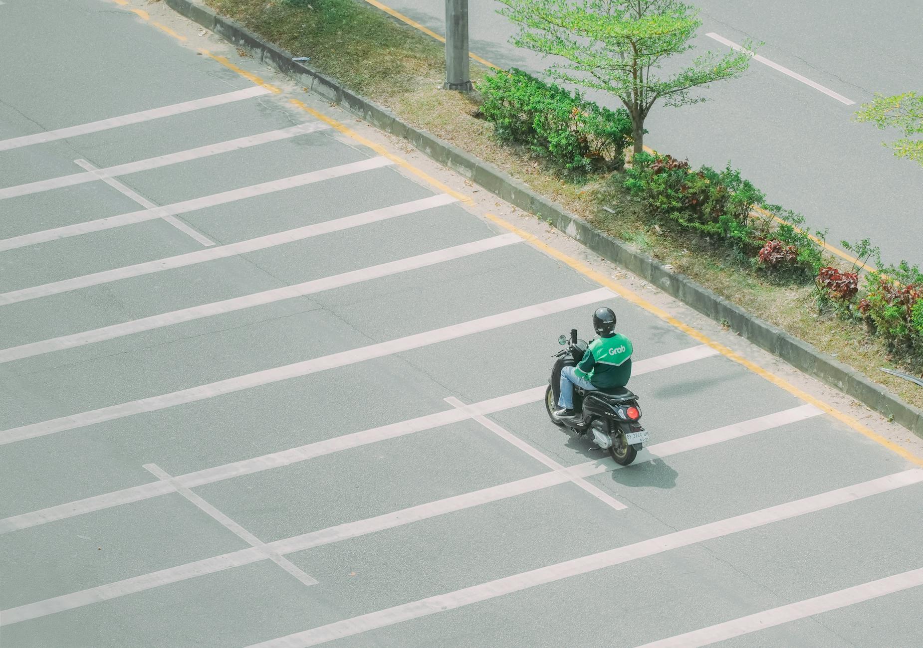 Motocykl jadący boczną asfaltową drogą w Malezji
